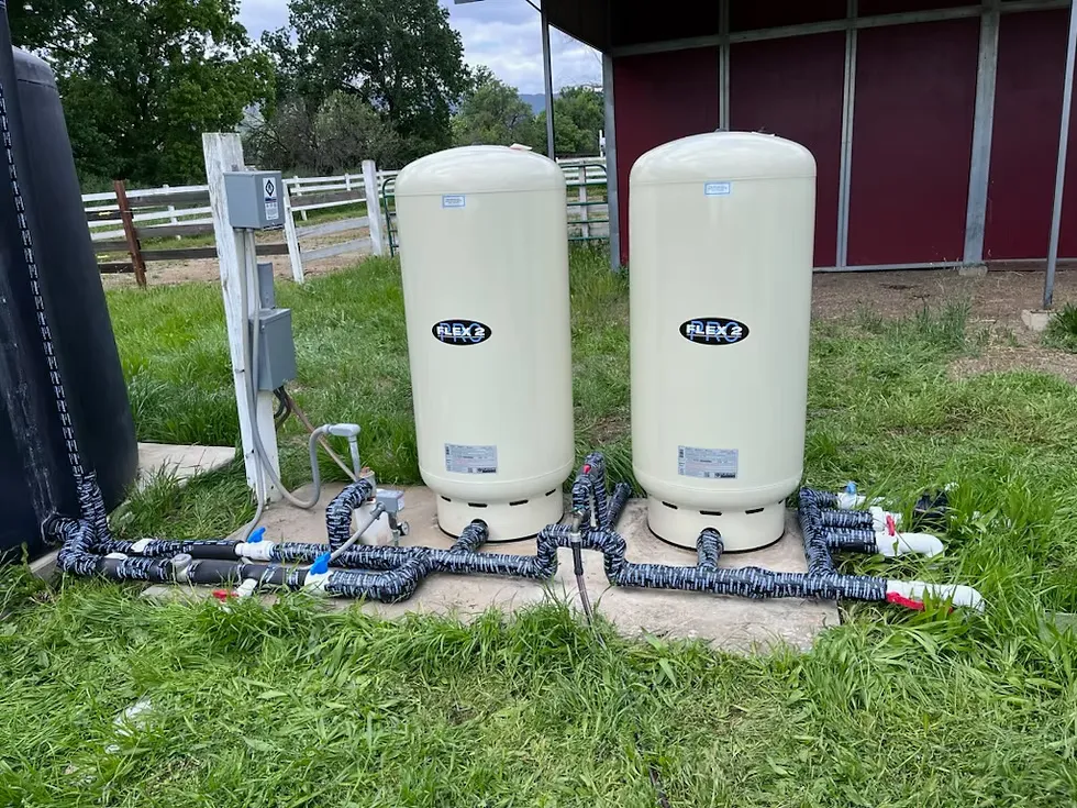 Pressure tanks for a residential well beside a barn